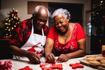 Joyful senior African-American couple cooks Christmas dinner at home. Happy black wife and husband prepare delicious food for family holiday. Positive people at table with treats in kitchen