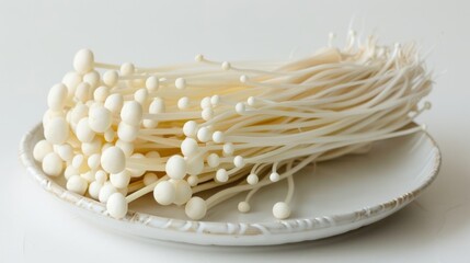 A bundle of enoki mushrooms on a ceramic plate. Concept of fresh produce, culinary ingredient, healthy eating, organic food
