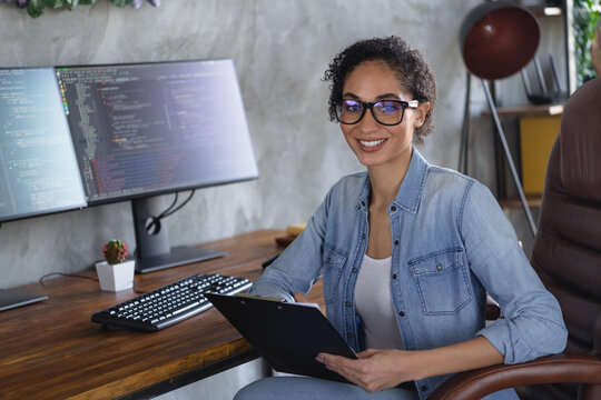 Portrait of young girl it specialist sitting chair hold clipboard loft interior business center indoors