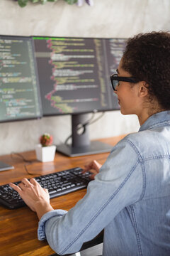 Vertical portrait of young girl it specialist write keyboard display loft interior business center indoors