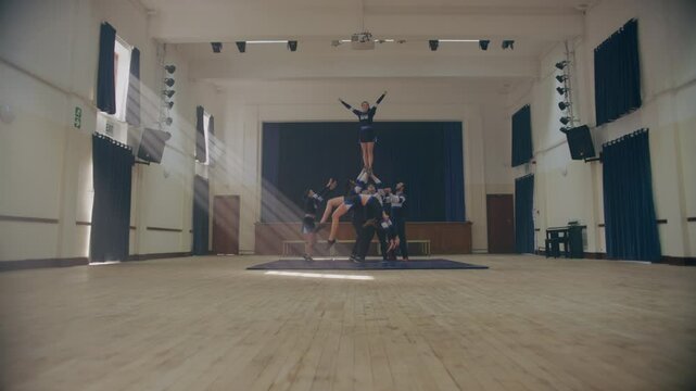 Male and female Cheerleaders practicing handstand and cartwheel