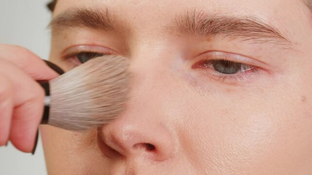Beauty shot of woman makeup artist applying foundation bb cream on previously applied moisturizing young woman face close-up. Concept of skincare, cosmetics, make up, beauty