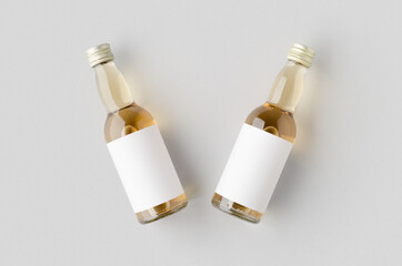 Miniature spirits, liquor bottle mockup. Clear glass, amber liquid with a blank label.