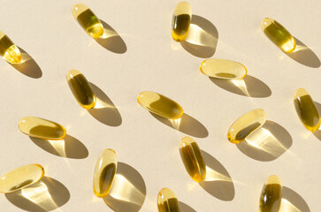 Fish oil capsules on a beige background. Medical concept.
