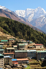 View onto a colorful neighborhood of Namche Bazaar, Bazar with Mount Kusum Kanguru, Kangguru rising in the background, Mount Everest Base Camp Trek, EBC, Nepal