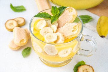 Banana Pudding Dessert on Glass cup. Layered parfait dessert with cookies and banana slices, copy space