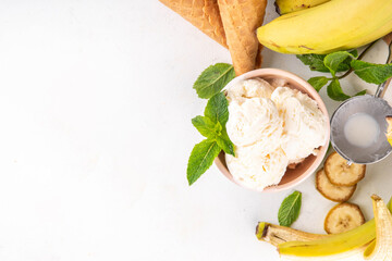 Vegan raw alternative banana ice cream,  frozen banana cream, sorbet or gelato with fresh bananas, mint and waffle ice cream cones, copy space