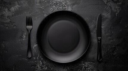 Dark background with black plate fork and knife in a restaurant setting