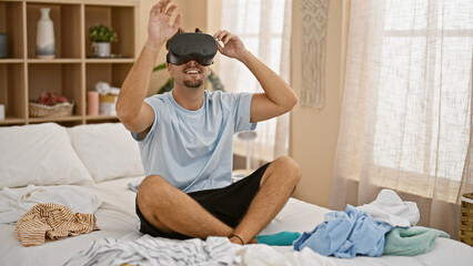 Hispanic man using vr headset in a messy bedroom, portraying technology use in a domestic setting.