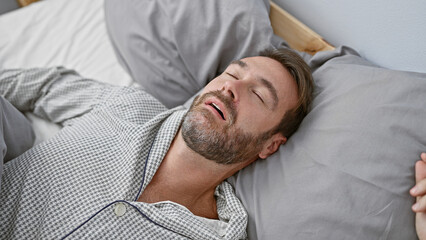 Handsome middle-aged hispanic man sleeping peacefully in a comfortable bedroom setting