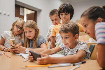 Young students use cellphone for video games on a break at school