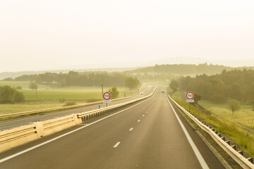 Motorway in France at dawn, speed limit signs to 110 kilometers per hour