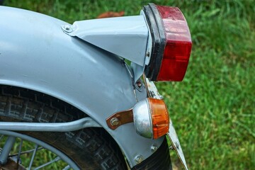 one red plastic square rear powerful electric red plastic brake light on gray iron fender with part...