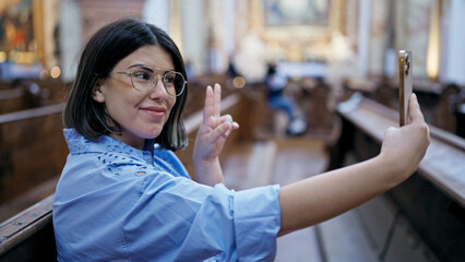 Young beautiful hispanic woman visiting church taking a selfie picture at St. Karl BorromÃ¤us...