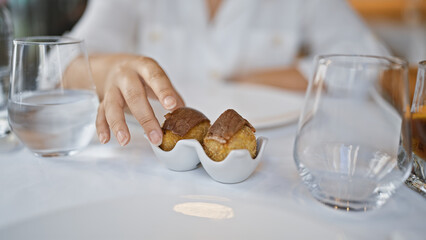 Young woman eating pastrami croquette at the restaurant