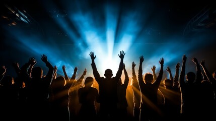 Vibrant concert crowd silhouetted under blue stage lights, energetic atmosphere with raised hands