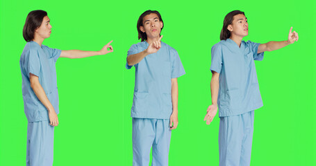 Obraz premium Medical assistant doing no symbol on camera, showing negative reaction and disagreement. Asian healthcare worker being displeased about something, disagreeing and disapproving.