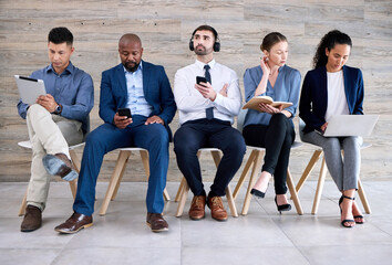 Fototapeta premium Recruitment, chair and row of people with opportunity, waiting and notes in book, laptop or tablet. Hiring, diversity and candidate group ready with phone, work interview and queue for vacancy