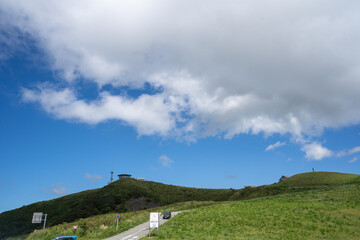 青空の下の寒風山を見上げる