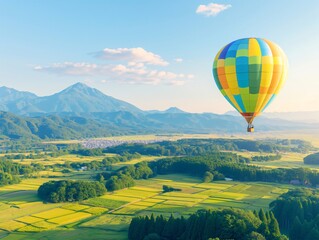 Obraz premium Colorful hot air balloon flying over beautiful landscape with rice paddy field and mountain