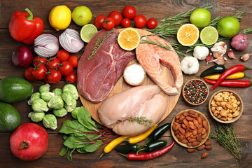 Flat lay composition with fresh meat and other products for balanced diet on wooden table