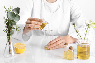 Aromatherapy product. Scientist developing essential oils at white table in laboratory, closeup