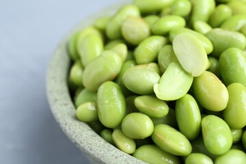 Fresh edamame soybeans in bowl on grey table, closeup