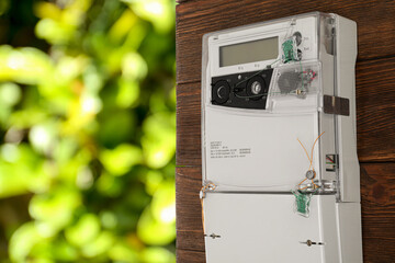Electricity meter on wall outdoors, space for text. Measuring device