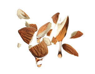 Oil dripping from crushed almonds on white background