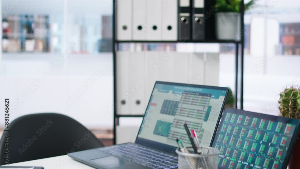 Poster laptop device on office desk in empty workspace showing volatile stock exchange prices going up and 