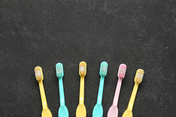 Colorful toothbrushes on black grunge background