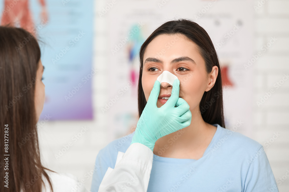 Sticker plastic surgeon and young woman with bandaged nose in clinic