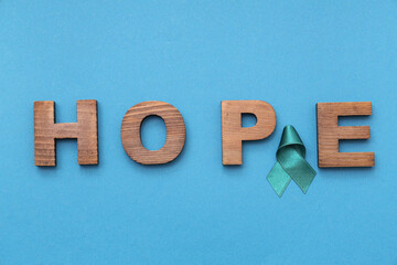 Teal ribbon and word HOPE on blue background. Sexual Assault Awareness Month