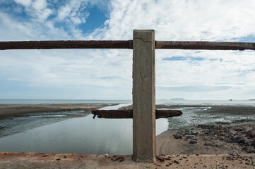 Concrete bridge is damaged and rusted.