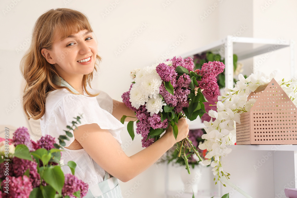 Wall mural female florist holding beautiful bouquet with lilacs in flower shop