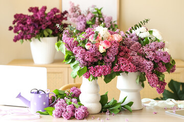 Vases with beautiful flowers on table in florist studio