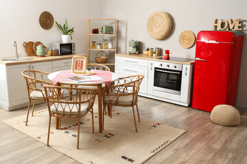 Interior of kitchen with red fridge, white counters and dining table