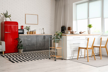 Stylish refrigerator and counters near white wall in kitchen