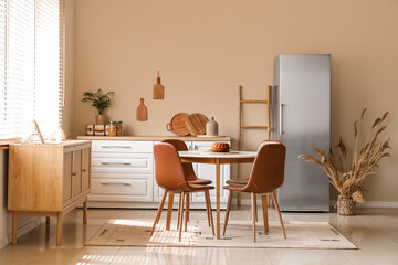Interior of light kitchen with stylish fridge, white counter and dining table