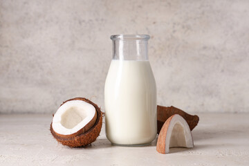 Bottle of tasty fresh coconut milk on grunge background, closeup
