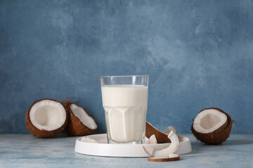 White tray and glass of tasty fresh coconut milk on blue grunge background