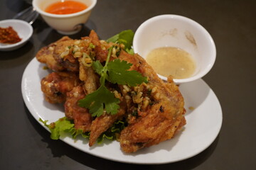 deep fried chicken with garlic, along with a bowl of lemon and pepper sauce 