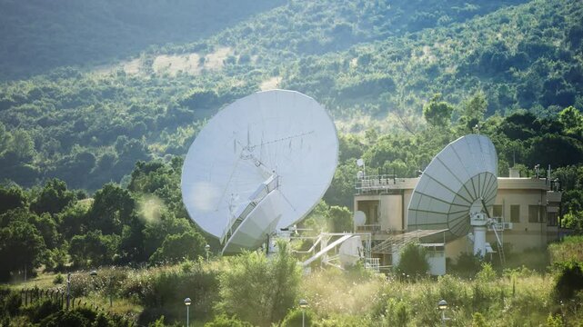 Technology background of surveillance spying center with satellite dish antennas on a hillside.