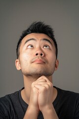 Obraz premium A person thoughtfully gazing upward with his hand resting on his chin