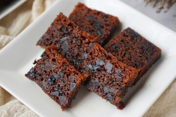 Kek Buah Kukus, a traditional Malaysian steamed fruit cake filled with dried fruits, nuts, and spices, enjoyed during celebrations.
