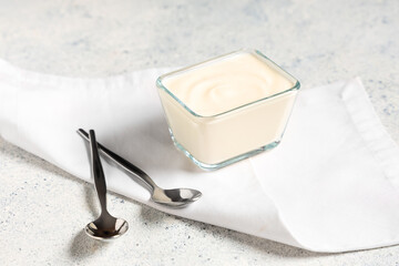 GLass bowl of tasty yogurt on white background
