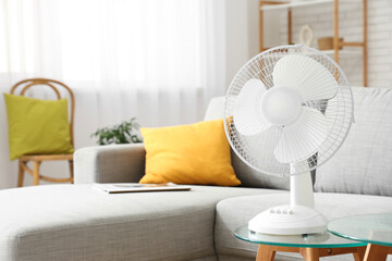 Modern electric fan on coffee table at home