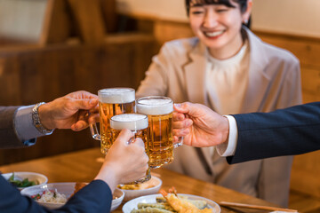 居酒屋・飲み屋で乾杯する男女のサラリーマン
