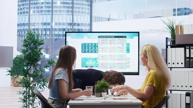 Employee choking in office, being helped by quick thinking coworker performing Heimlich maneuver. Worker offering first aid to colleague while coworker calls for ambulance, camera B