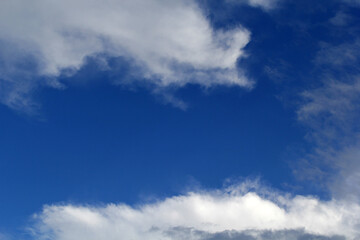 Blue sky with scattered white clouds abstract background